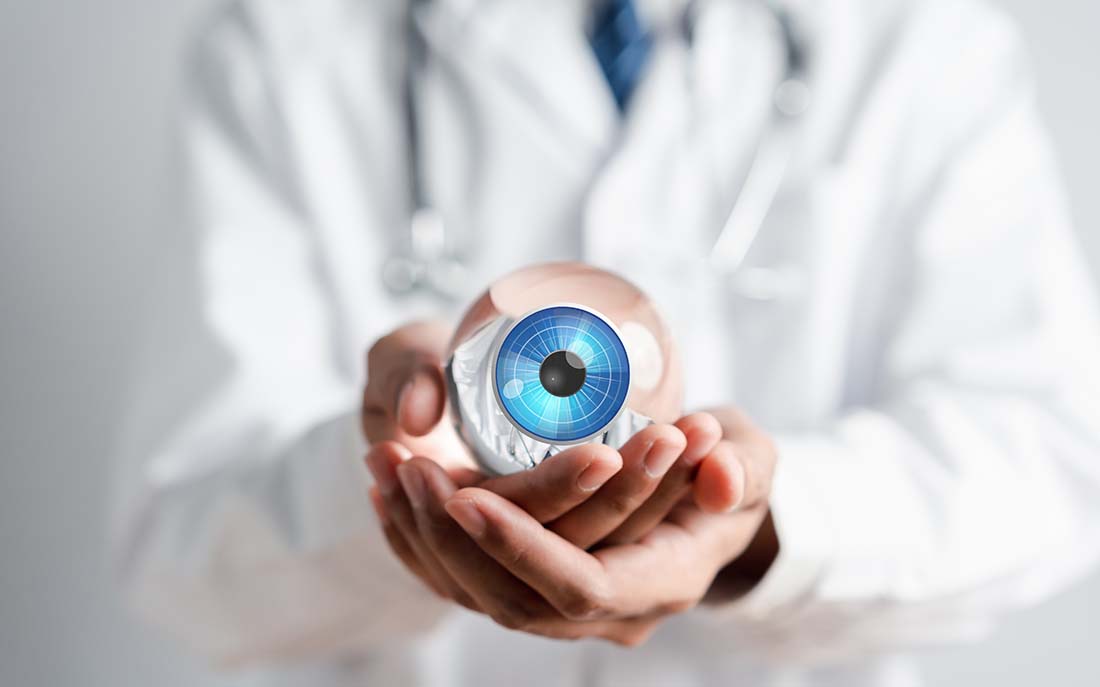 Doctor holding an enlarged glass eye for teaching purposes