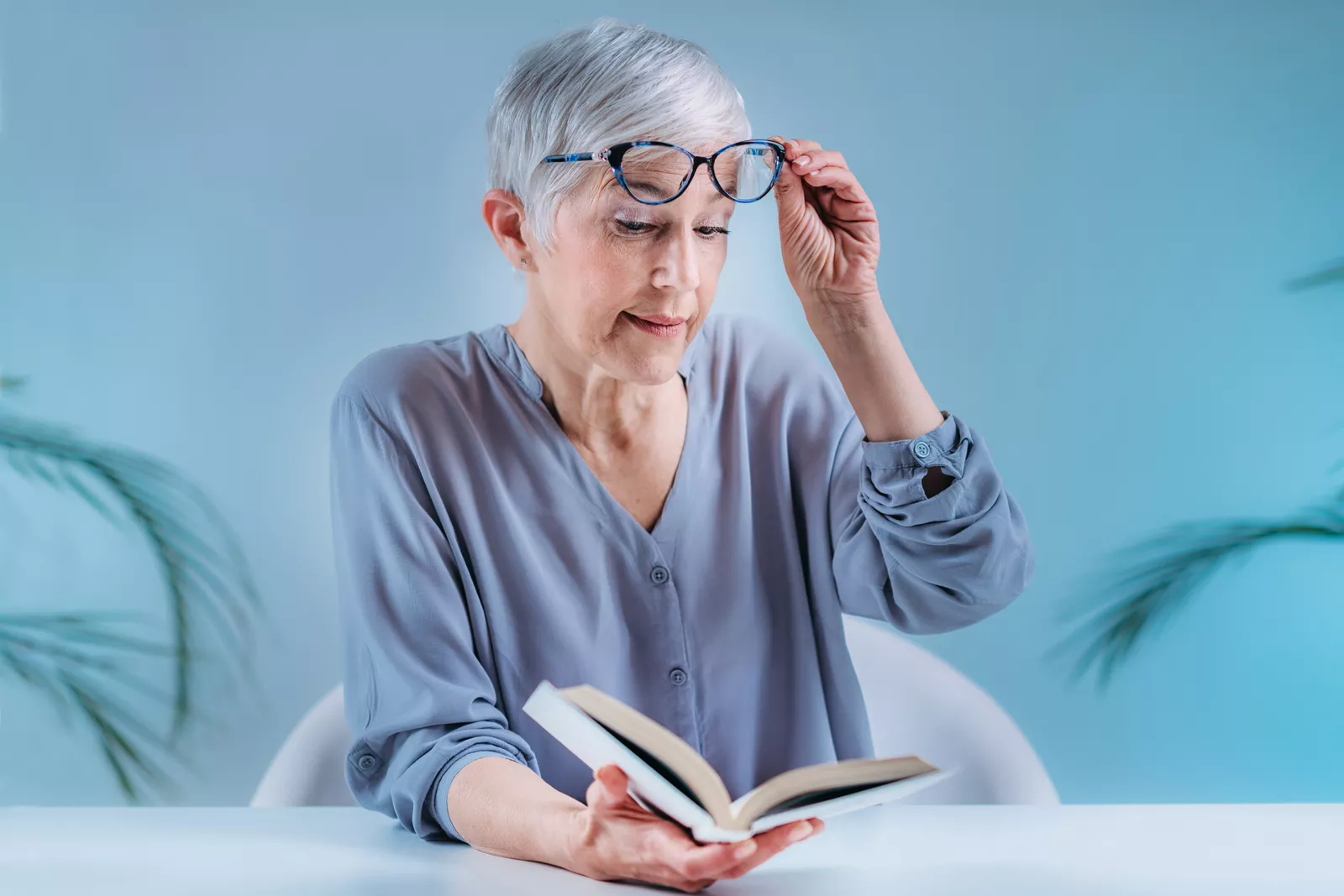 Woman reading with glasses on top of her head.